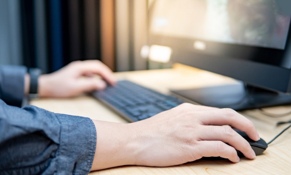 worker sitting at a desk on the computer using employee self-service